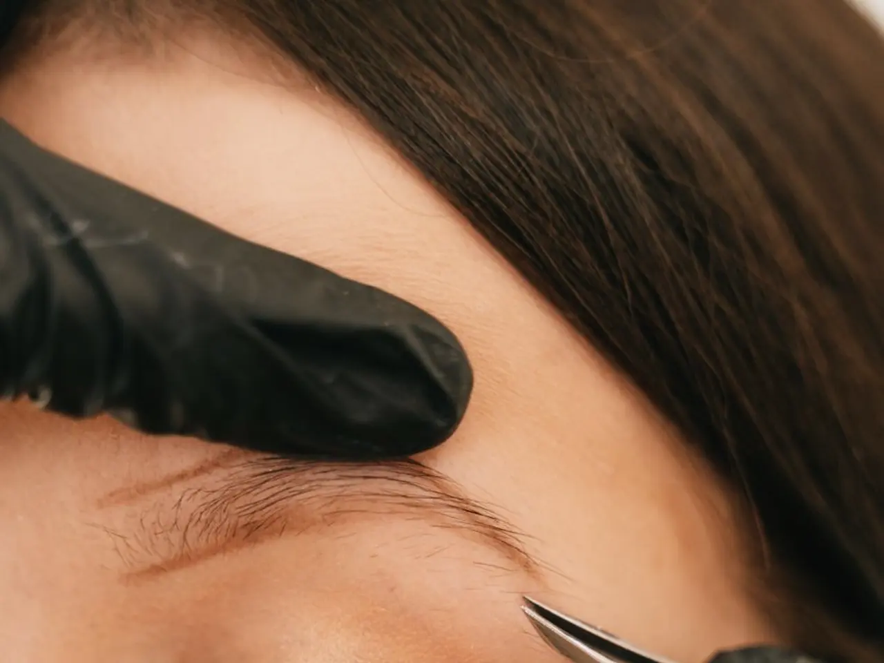 Profissional fazendo design de sobrancelha com pinça em close