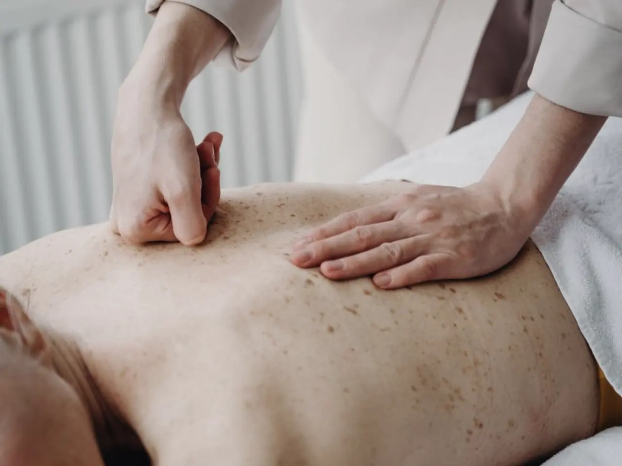 Massagem modeladora aplicada por profissional de jaleco em ambiente clínico